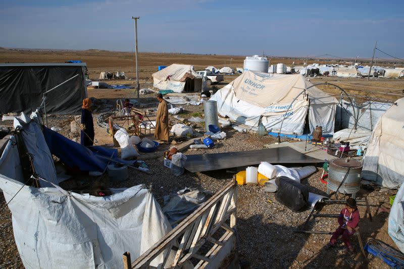 Displaced Iraqis collect their belongings at Hammam Al-Alil camp where they prepare to be evacuated, south of Mosul