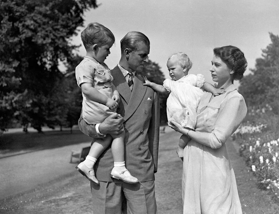 <p>Elizabeth and Philip with their children, Charles and Anne, in 1951 in the grounds of Clarence House. Princess Anne was born there on 15 August 1950. (AFP via Getty Images)</p> 