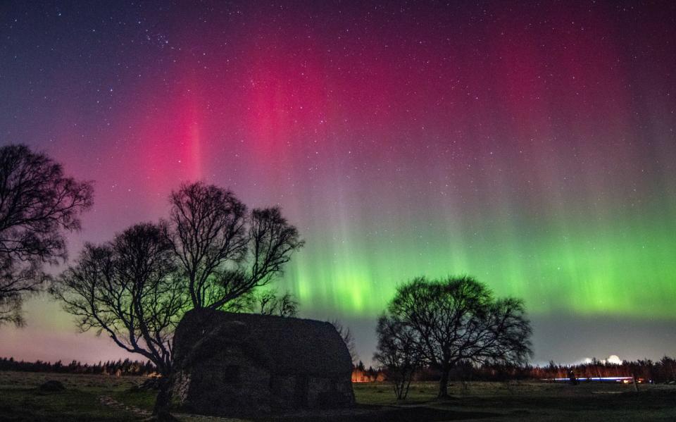 Auroras seltenes tiefrotes Lichtspiel über dem Schlachtfeld von Culloden, in der Nähe von Inverness, Schottland - Land of Light Photography/Bav Media