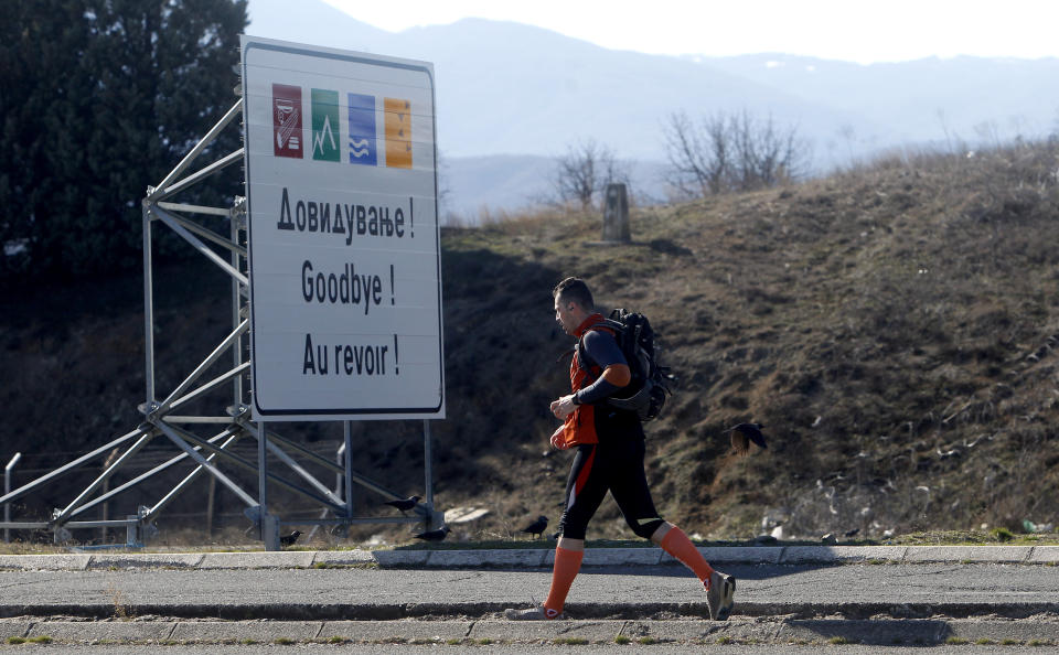 A man walks, leaving Macedonia and entering into Greece, at Bogorodica border crossing on Macedonia's southern border with Greece, Tuesday, Feb. 12, 2019. Macedonian authorities began Monday removing official signs from government buildings to prepare for the country's new name: North Macedonia. (AP Photo/Boris Grdanoski)