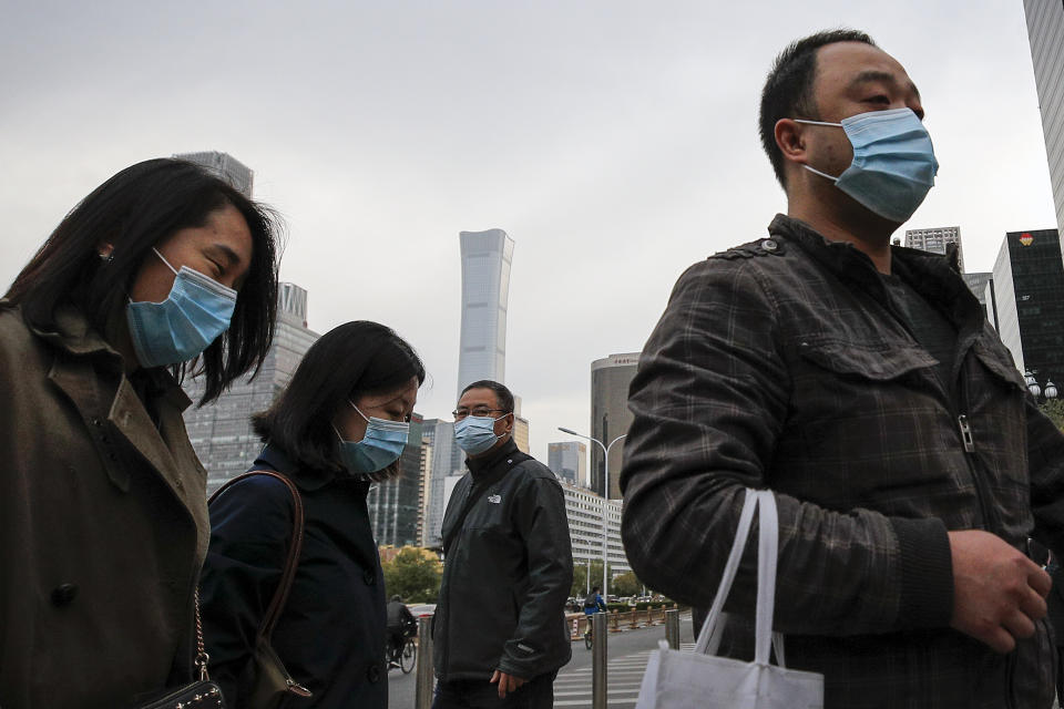 Commuters wearing face masks to help curb the spread of the coronavirus walk out from a subway station during the morning rush hour in Beijing, Thursday, Oct. 29, 2020. (AP Photo/Andy Wong)