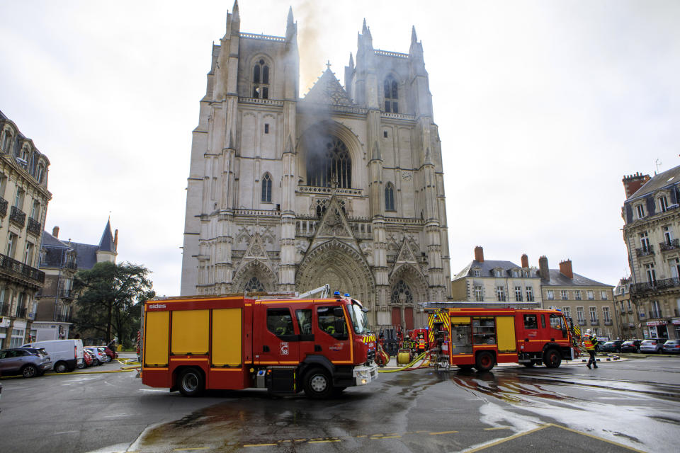 Fire fighters brigade work to extinguish the blaze at the Gothic St. Peter and St. Paul Cathedral, in Nantes, western France, Saturday, July 18, 2020. The fire broke, shattering stained glass windows and sending black smoke spewing from between its two towers of the 15th century, which also suffered a serious fire in 1972. The fire is bringing back memories of the devastating blaze in Notre Dame Cathedral in Paris last year that destroyed its roof and collapsed its spire and threatened to topple the medieval monument. (AP Photo/Laetitia Notarianni)