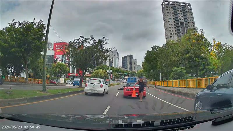 車禍發生後，被擦撞的紅色敞篷車駕駛從車上拿出摺疊三角錐擺放示警。(圖／翻攝自「台中市西屯區大小事」臉書)