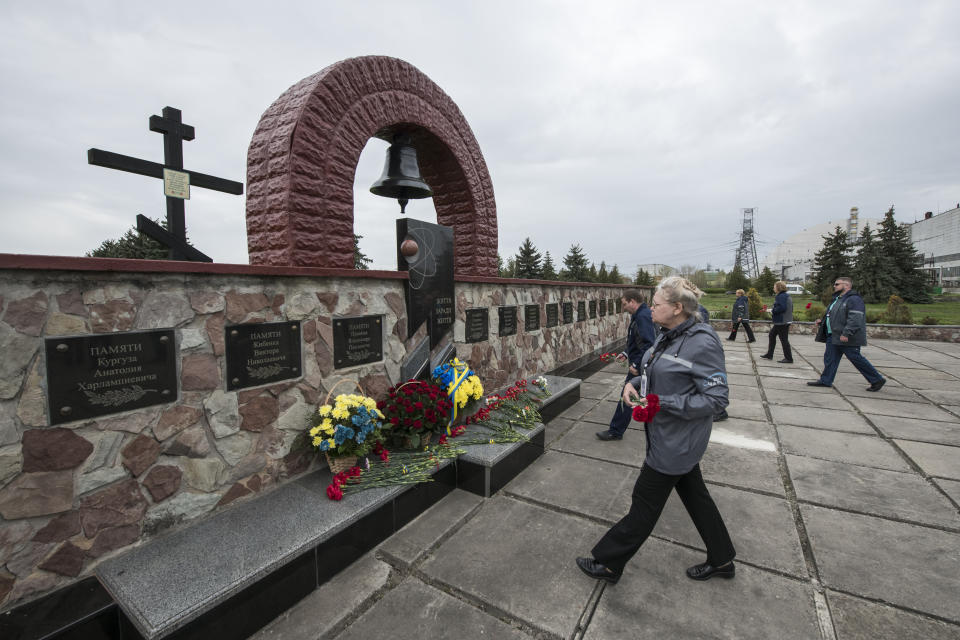 Chernobyl's nuclear power plant workers lay flowers at a monument to the victims of the Chernobyl tragedy during a memorial ceremony in Chernobyl, Ukraine, Wednesday, April 26, 2023. Ukrainian President Volodymyr Zelenskyy on Wednesday used the 37th anniversary of the world’s worst nuclear disaster to repeat his warnings about the potential threat of a new atomic catastrophe in Ukraine amid his country's war with Russia. (AP Photo/Wladyslaw Musiienko)