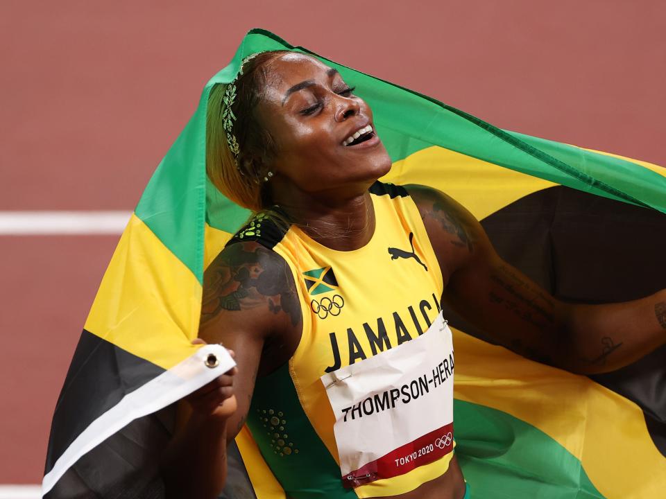 Elaine Thompson-Herah of Team Jamaica celebrates after winning the gold medal in the Women's 100m final (Getty)