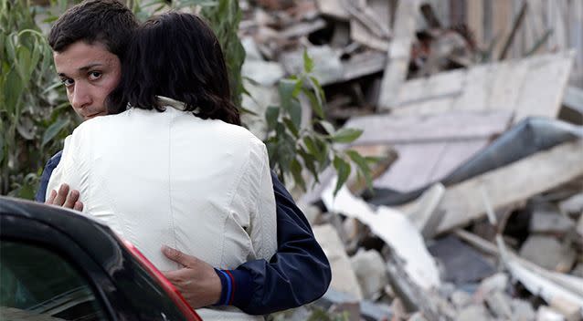 Two people hug each other next to the remains of a collapsed house following an earthquake in Pescara Del Tronto. Photo: AP/Gregorio Borgia