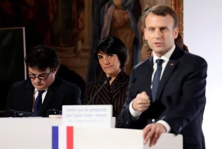 French President Emmanuel Macron (R) stands in front of Florence Foresti, French humorist and patron of association 'Women Safe', and French writer, activist and physicianPatrick Pelloux as he delivers a speech during the International Day for the Elimination of Violence Against Women, at the Elysee Palace in Paris, France, November 25, 2017. REUTERS/Ludovic Marin/Pool