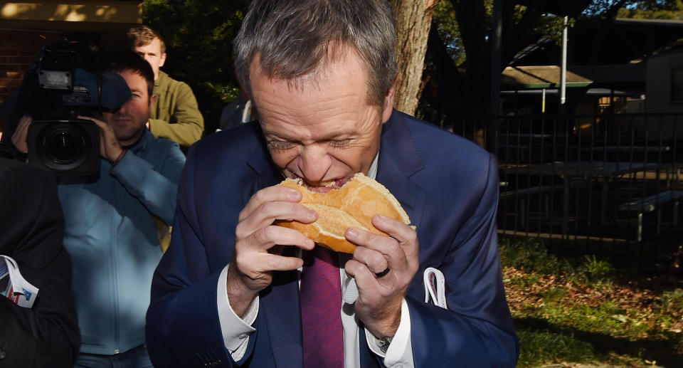 Bill Shorten bites into a hot dog