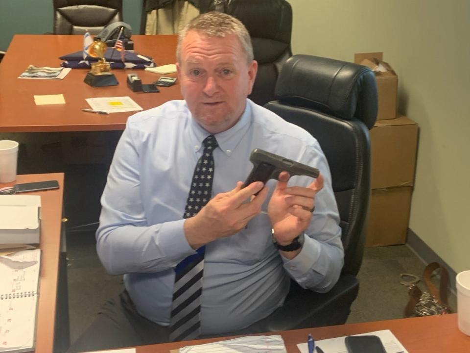 Sheriff Buddy Harwood poses with Bobby Hicks' Browning pistol. Harwood returned the gun - which was stolen from Hicks in Greensboro in 1978 - to the famed musician April 15.