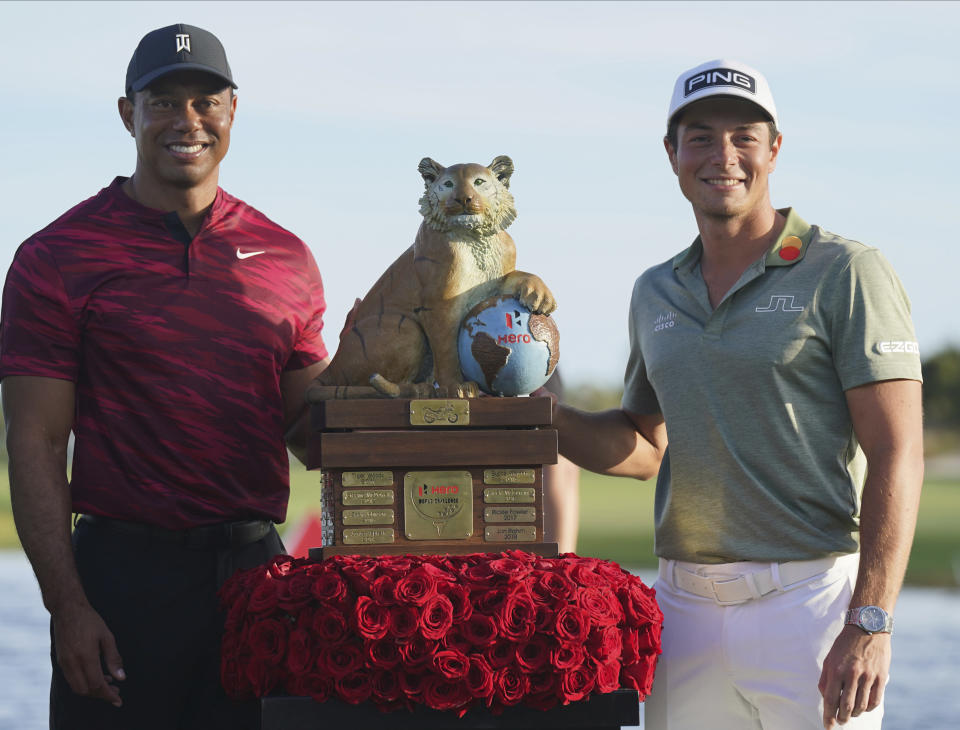 Viktor Hovland, of Norway, right, and Tiger Woods pose with the championship trophy after the final round the Hero World Challenge PGA Tour at the Albany Golf Club, in New Providence, Bahamas, Sunday, Dec. 5, 2021. Viktor Hovland won the tournament with -17 strokes. (AP Photo/Fernando Llano)