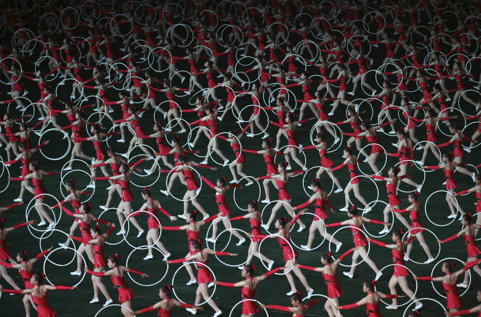 FILE - In this July 22, 2013, file photo, North Korean girls perform in Pyongyang, North Korea. North Korea is bringing back one of its most iconic art forms - mass games performed by tens of thousands of people working in precise unison - to mark its 70th anniversary on Sunday, Sept. 9, 2018. The performance, which takes months if not years of intense preparation and training, is being called “Glorious Country” this year. (AP Photo/Wong Maye-E, File)