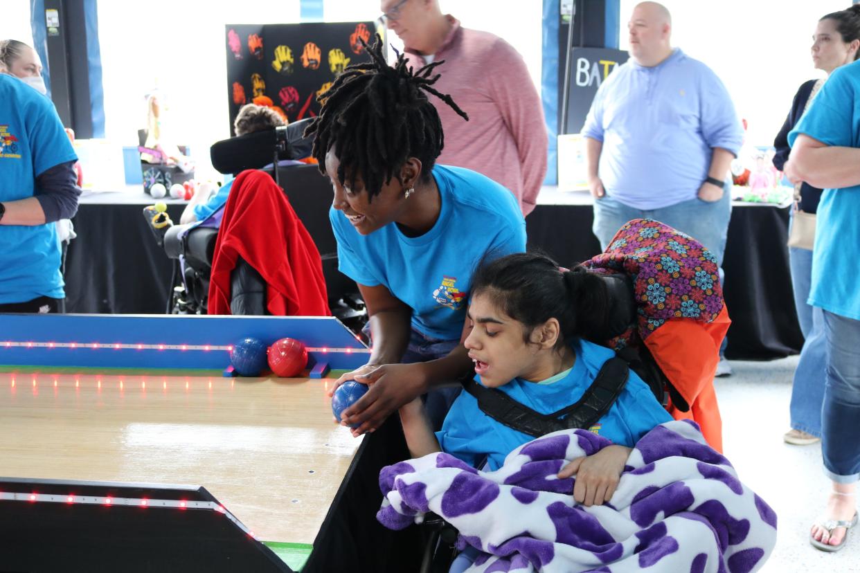 Qualified Professional Samone Wall helps resident Bhoomi bowl during Angel Bowl.