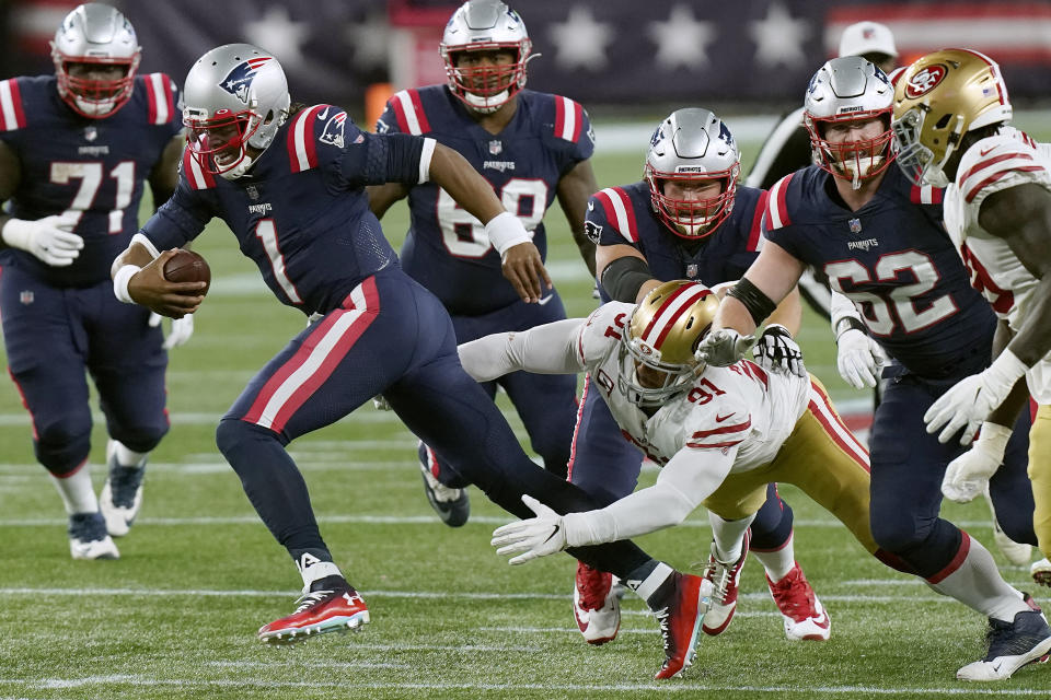 New England Patriots quarterback Cam Newton (1) runs from the grasp of San Francisco 49ers defensive end Arik Armstead (91) in the second half of an NFL football game, Sunday, Oct. 25, 2020, in Foxborough, Mass. (AP Photo/Steven Senne)