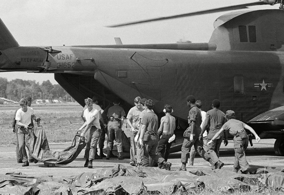 Bodies of victims of Jonestown mass suicide are loaded from U.S. military helicopter at Georgetown's international airport. The corpses, in body bags, will be transferred to shipping containers for the flight back to the U.S.