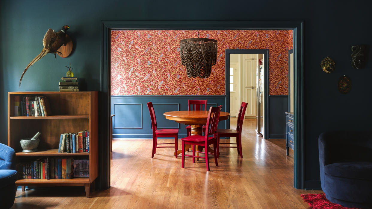  Shot from living room to dining room with dark blue trim and red wallpaper. 