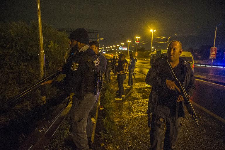 South African police patrol during a standoff with looters on the National Highway in Johannesburg on April 18, 2015