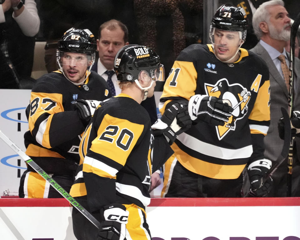 Pittsburgh Penguins' Lars Eller (20) is congratulated by Sidney Crosby (87) and Evgeni Malkin (71) for his goal against the New York Islanders during the second period of an NHL hockey game in Pittsburgh, Tuesday, Feb. 20, 2024. (AP Photo/Gene Puskar)