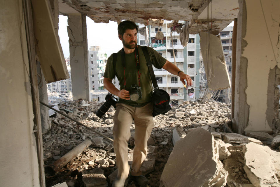 <p>Getty Images photographer Chris Hondros walks the ruins of a building August 21, 2006 in southern Beirut, Lebanon. Hondros, who was on assignment in Misrata, Libya, was killed on April 20, 2011 by a rocket-propelled grenade (RPG). (Photo by Getty Images) </p>