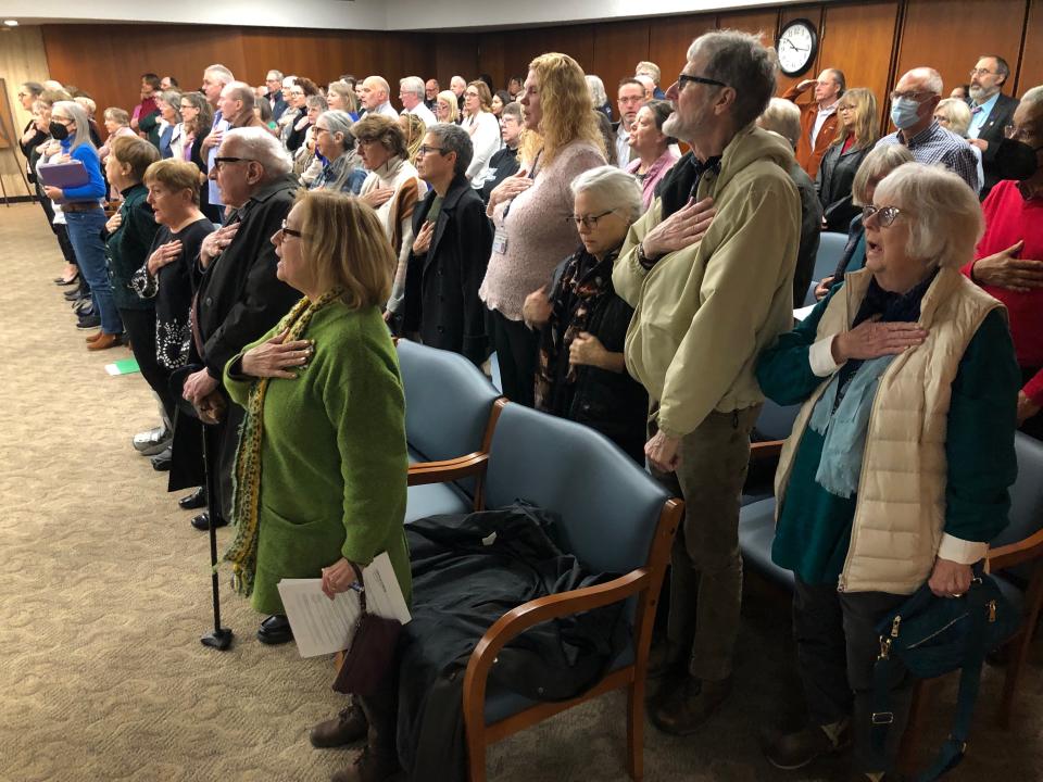 A full crowd says the "Pledge of Allegiance" at the St. Joseph County Commissioners meeting on Dec. 12, 2023, many of them having come on the issue of appointing a library board member.