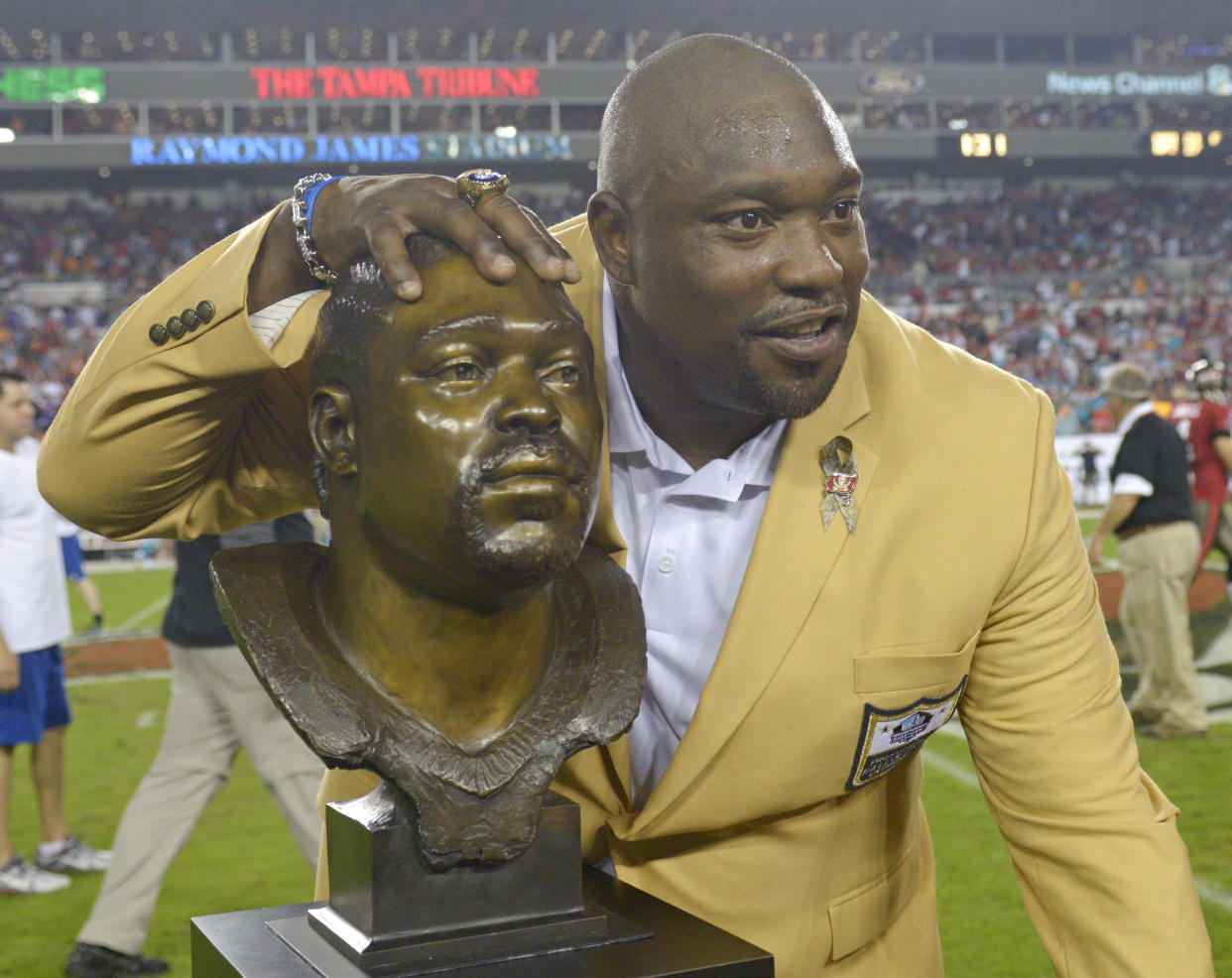 Warren Sapp sonríe con un busto otorgado por los Tampa Bay Buccaneers en su honor (AP Photo/Phelan M. Ebenhack)