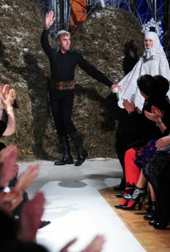 French designer Philippe Guilet acknowledges the audience after a fashion event called "100%.RO" held at the French embassy headquarters in Bucharest. Sheepskin skirts and delicate bead embroidery shone on the catwalk in a one-of-a-kind ethnic fashion show blending the skills of the French designer and centuries-old Romanian handicraft