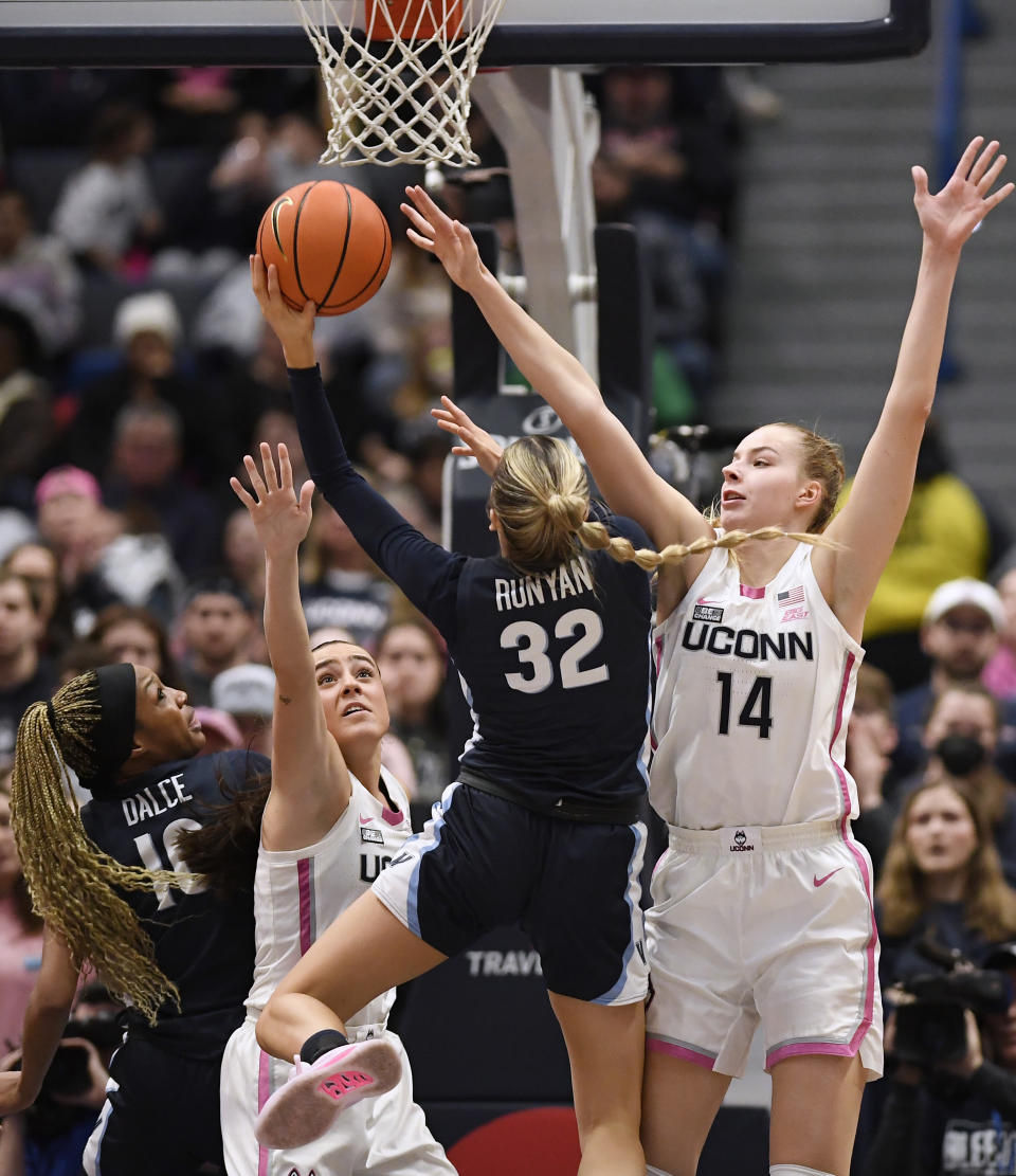 Villanova's Bella Runyan (32) shoots between UConn's Nika Muhl, second from left, and Dorka Juhasz, right, as Villanova's Christina Dalce, left, defends in the second half of an NCAA college basketball game, Sunday, Jan. 29, 2023, in Hartford, Conn. (AP Photo/Jessica Hill)