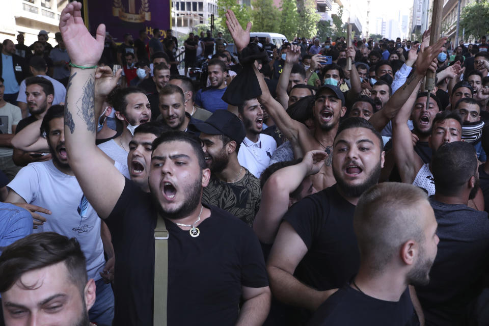 Hezbollah and Amal supporters stand in front of Lebanese army as they shout slogans against anti-government protesters, in downtown Beirut, Lebanon, Saturday, June 6, 2020. Hundreds of Lebanese demonstrators gathered in central Beirut Saturday, hoping to reboot nationwide anti-government protests that began late last year amid an unprecedented economic and financial crisis. (AP Photo/Bilal Hussein)