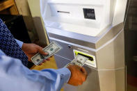 FILE PHOTO: A man feeds money into a Bitcoin ATM at the Bitcoin Center NYC in New York, U.S. on November 27, 2017. REUTERS/Brendan McDermid/File Photo