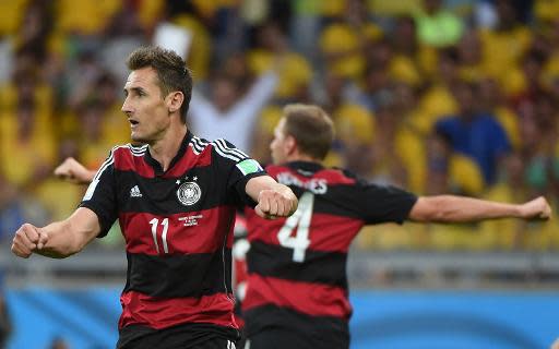 Germany's forward Miroslav Klose (L) and Germany's defender Benedikt Hoewedes celebrate a goal during the semi-final football match between Brazil and Germany at The Mineirao Stadium in Belo Horizonte on July 8, 2014