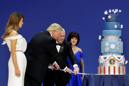 U.S. President Donald Trump with his wife Melania and Vice President Mike Pence with his wife Karen cut a cake at the Armed Services Ball in Washington, U.S., January 20, 2017. REUTERS/Yuri Gripas