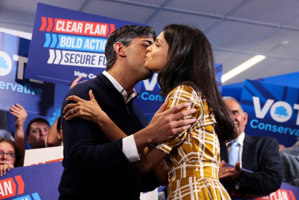 Rishi Sunak and his wife Akshata Murty kiss during his final rally (POOL/AFP via Getty Images)