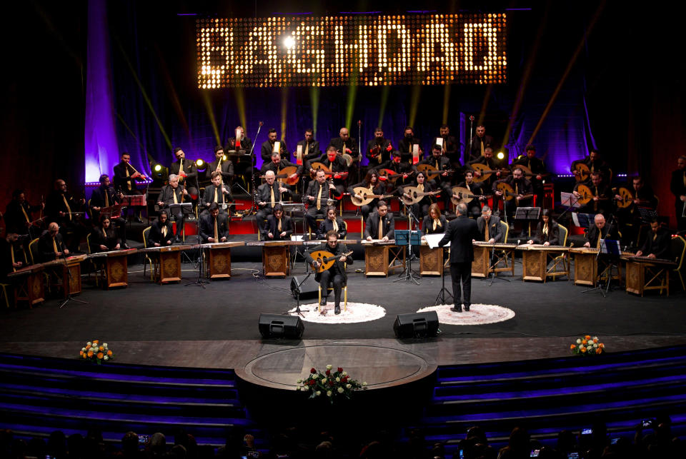 Iraqi virtuoso oud player Naseer Shamma performs with an orchestra -- half of them young women musicians -- at the Iraqi National Theater in Baghdad, Iraq, Friday, Jan. 21, 2022. War kept him away from his beloved homeland for decades. Now Shamma has returned to Iraq with a series of concerts and projects he hopes will support education, culture and the arts in the conflict-scarred nation. (AP Photo/Hadi Mizban)