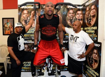 Floyd Mayweather Jr. (C) works out at the Mayweather Boxing Club with CEO of Mayweather Promotions Leonard Ellerbe (L) and gym manager and The Money Team assistant Solomon Sinclair (R). (Photo by Ethan Miller/Getty Images)