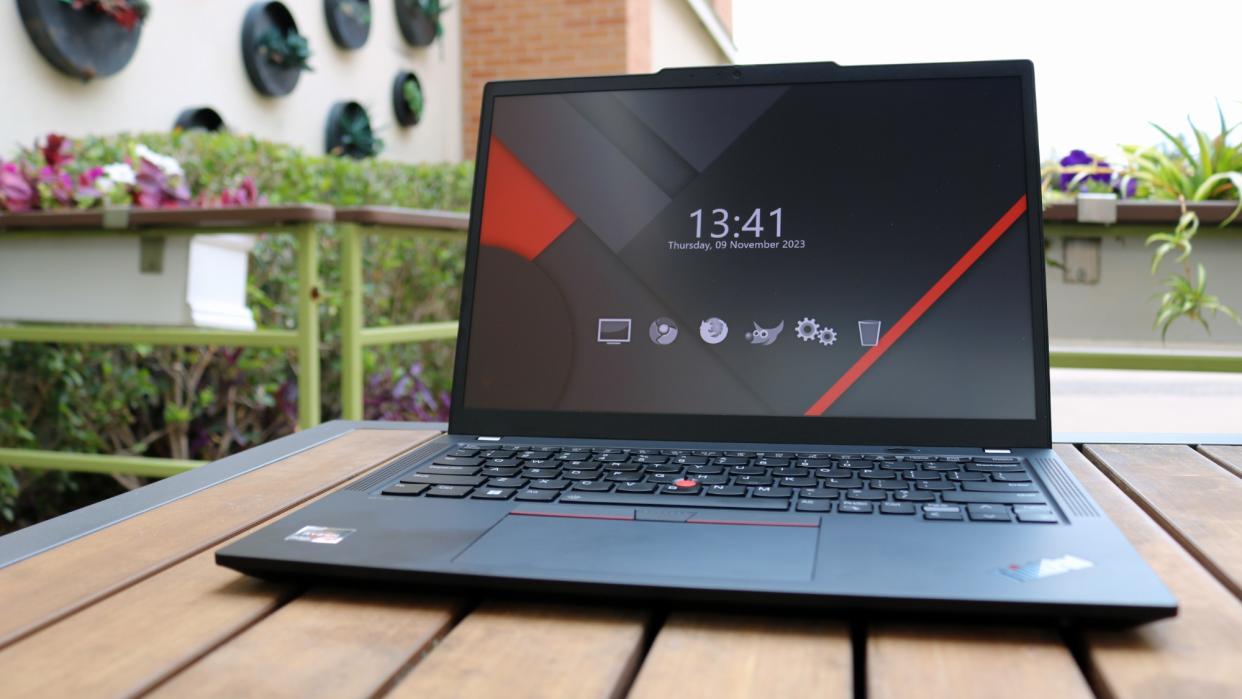  ThinkPad X13 Gen 4 on wood table outside . 