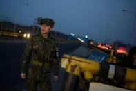 A soldier stands before a barricade at the Tongil bridge, a checkpoint leading to the Kaesong joint industrial zone, in Paju on February 11, 2016