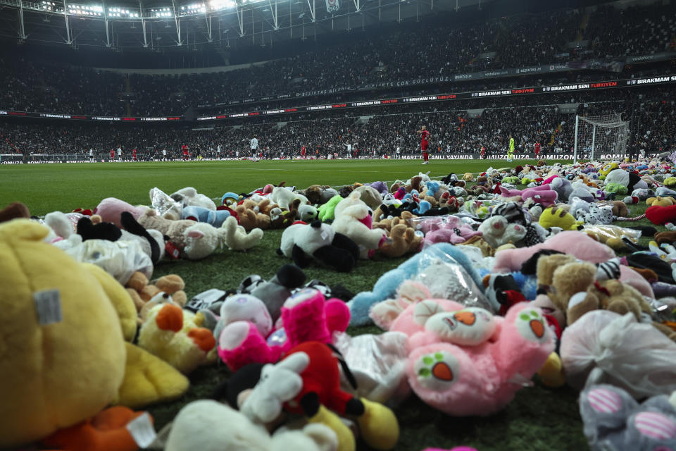 Players resume the game after fans threw toys onto the pitch during the Turkish Super League soccer match between Besiktas and Antalyaspor at the Vodafone stadium in Istanbul, Turkey, Sunday, Feb. 26, 2023. During the match, supporters threw a massive number of soft toys to be donated to children affected by the powerful earthquake on Feb. 6 on southeast Turkey. (AP Photo)