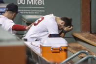 Boston Red Sox's Michael Chavis sits in the dugout as he is consoled by a teammate after he struck out for the fifth time for the final out of the team's loss to the Philadelphia Phillies in a baseball game Tuesday, Aug. 18, 2020, at Fenway Park in Boston. (AP Photo/Winslow Townson)