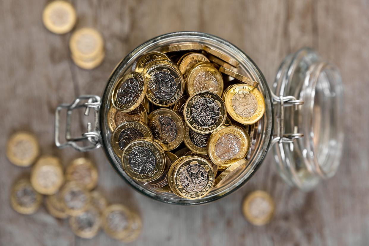 A jar full of saved one pound coins.