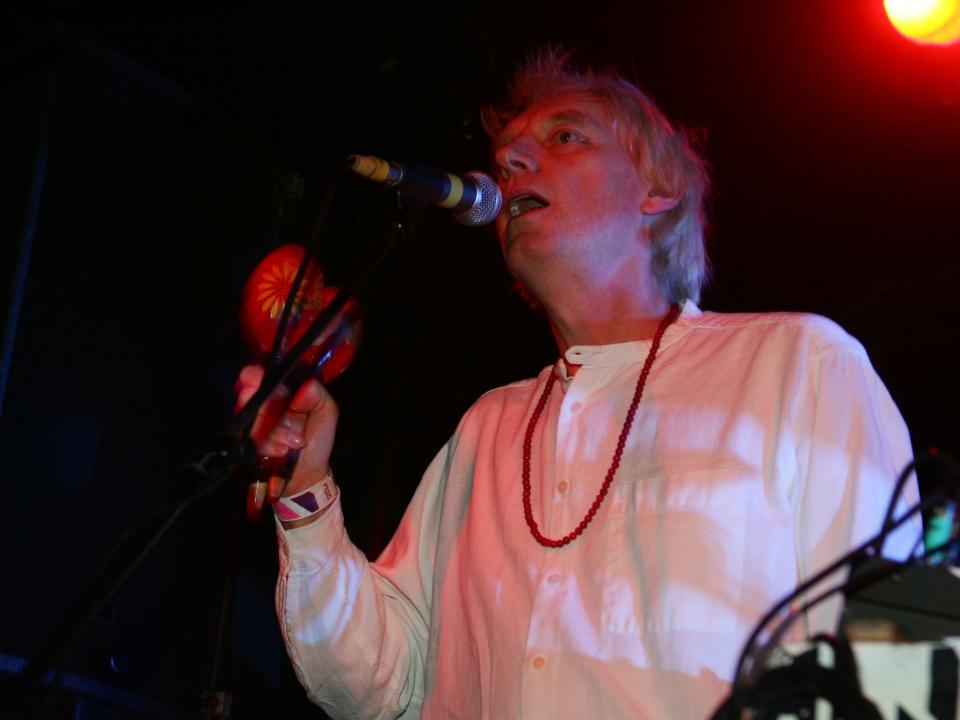 A person sining into a microphone with red lighting