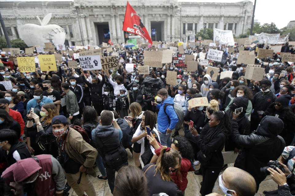 People gather calling for justice for George Floyd, who died May 25 after being restrained by police in Minneapolis, USA, in Milan, Italy, Sunday, June 7, 2020. People have been protesting throughout Italy, to denounce the police killing of George Floyd and show solidarity with anti-racism protests in the U.S. and elsewhere. (AP Photo/Luca Bruno)