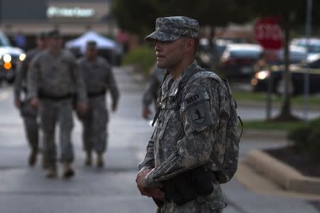 A member of the National Guard stands guard at a staging area inside a shopping center parking lot in Ferguson, Missouri August 21, 2014. REUTERS/Adrees Latif