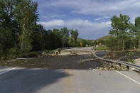 A river flows through a missing section of a key bridge that leads to the tourist town of Fishtail, Mont. Friday, June 17, 2022. (AP Photo/David Goldman)