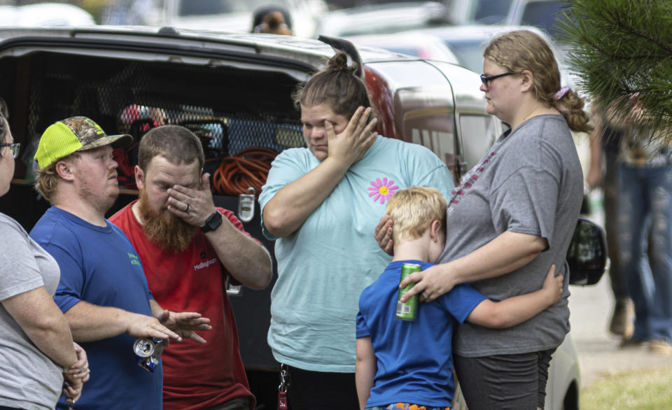 Family and friends gather near where fire and law enforcement investigators were on the scene of a house fire in Newnan, Ga. on Monday, June 17, 2024. (John Spink/Atlanta Journal-Constitution via AP)