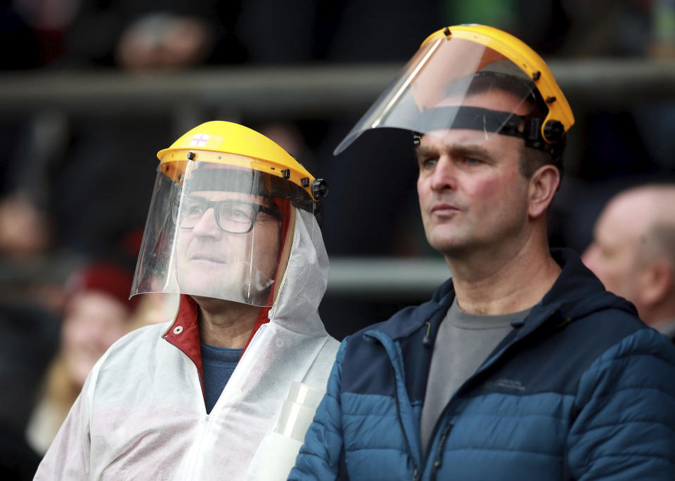 Spectators wear masks in the stands during the Six Nations international rugby union match between England and Wales at Twickenham Stadium, London, Saturday March 7, 2020. (Adam Davy/PA via AP)