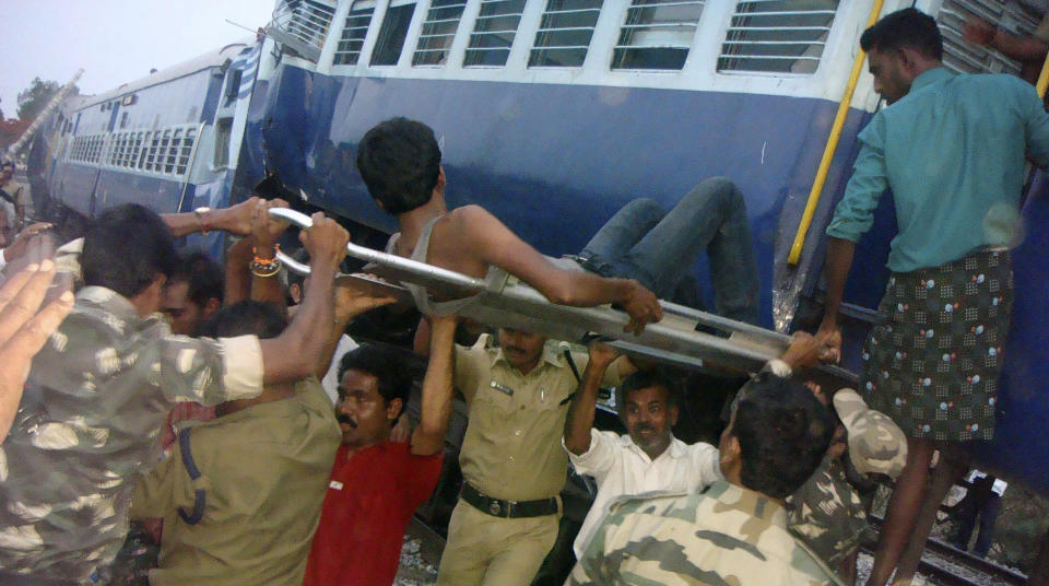 Rescuers evacuate an injured from the site of a train accident at a station near Penukonda, about 170 kilometers (105 miles) north of Bangalore, India, Tuesday, May 22, 2012. The passenger train rammed into a parked freight train and burst into flames before dawn Tuesday, killing more than a dozen people in southern India, officials said. (AP Photo)