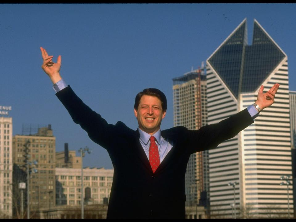 1988 Democratic presidential candidate Al Gore raising his arms triumphantly in front of the Chicago skyline.