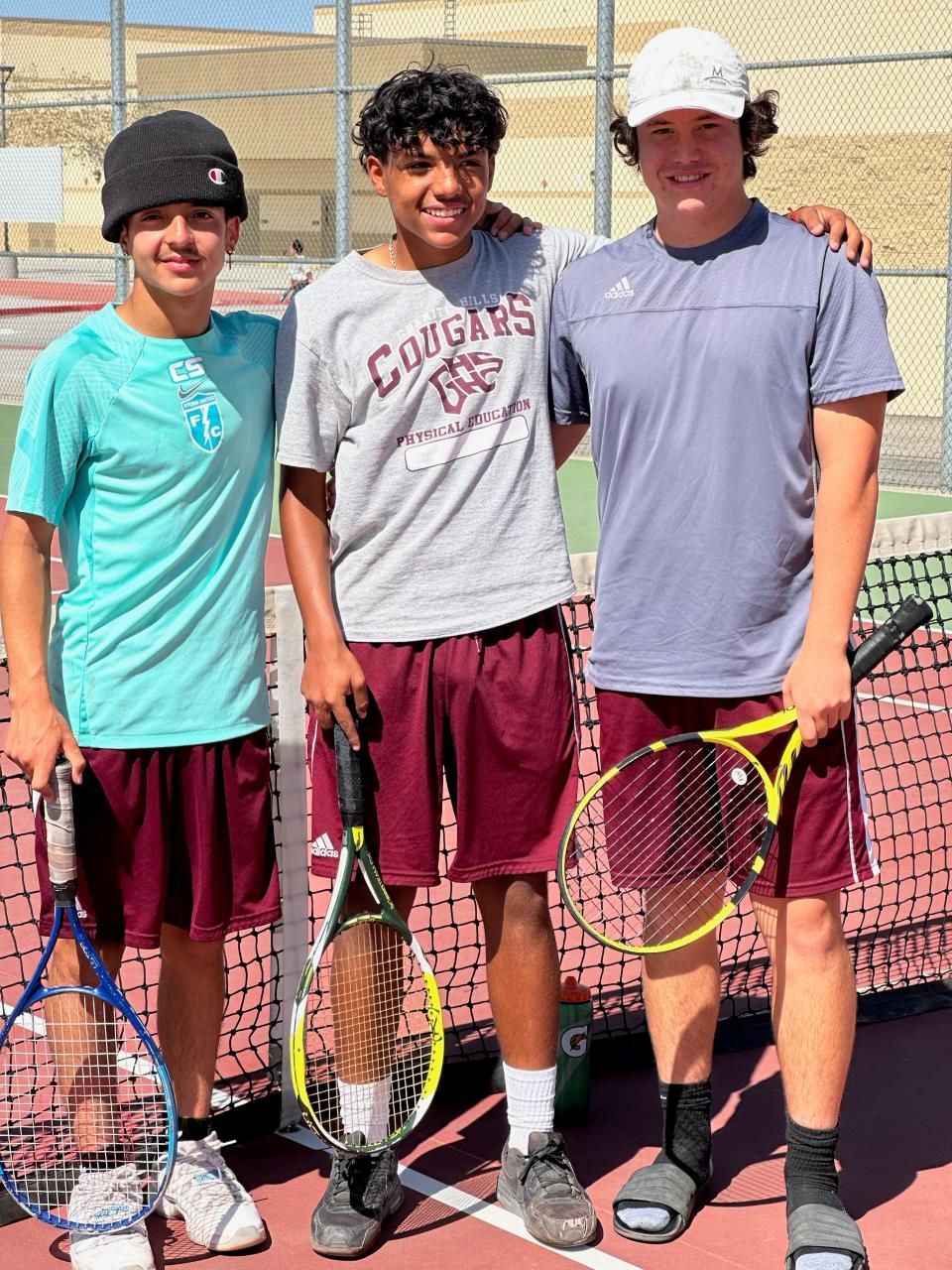 Granite Hills' doubles team of Cesar Sainz, left, and Erick Valdovinos pose for a photo with singles player Eric Poindexter, right, after capturing Desert Sky League boys tennis titles, at Adelanto High School, on Wednesday.