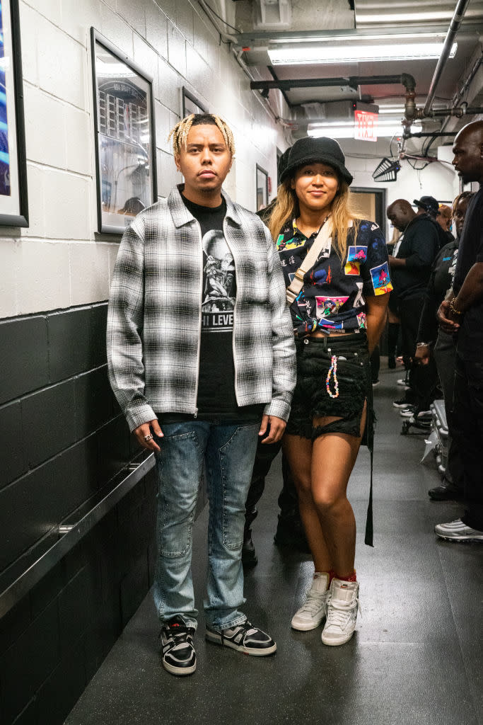 Naomi and Cordae standing in a hallway