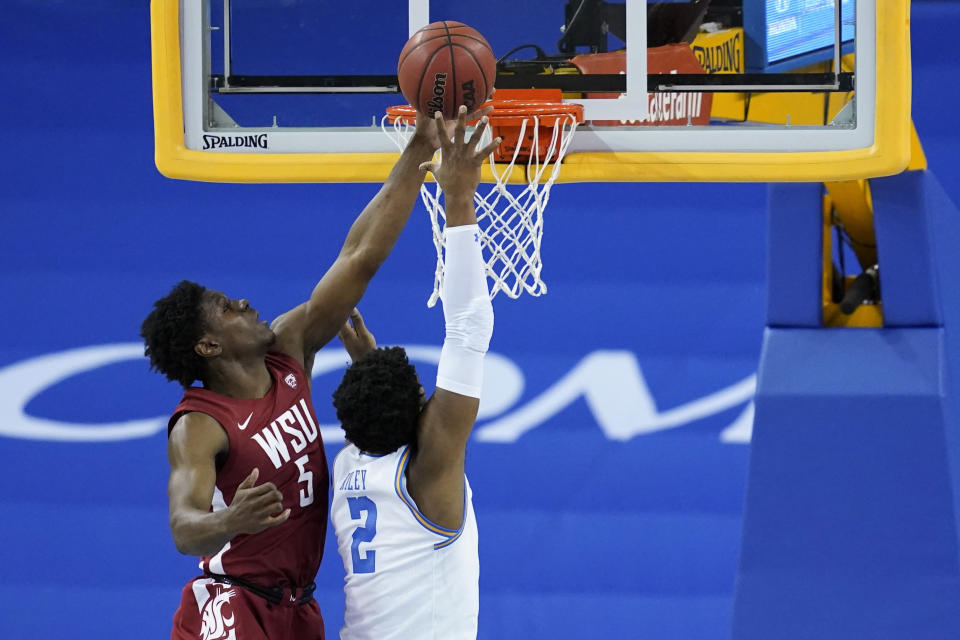 Washington State guard T.J. Bamba (5) deflects a shot by UCLA forward Cody Riley (2) during the first half of an NCAA college basketball game Thursday, Jan. 14, 2021, in Los Angeles. (AP Photo/Ashley Landis)