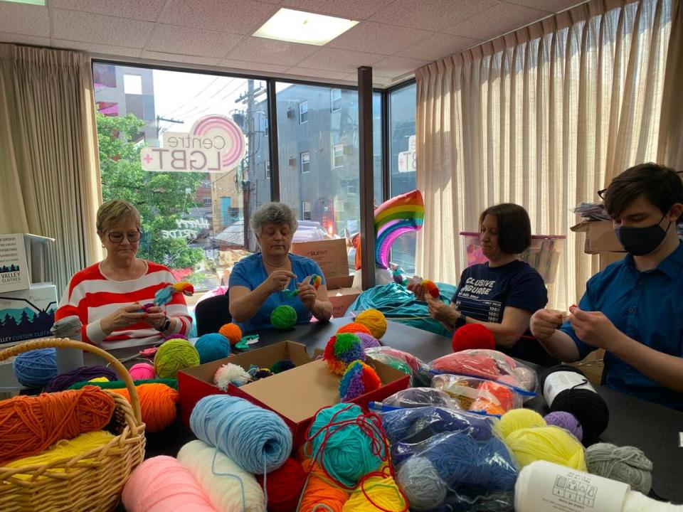 Members of Free Mom Hugs make “portable hug” pompoms at the CentreLGBT+ center in downtown State College.